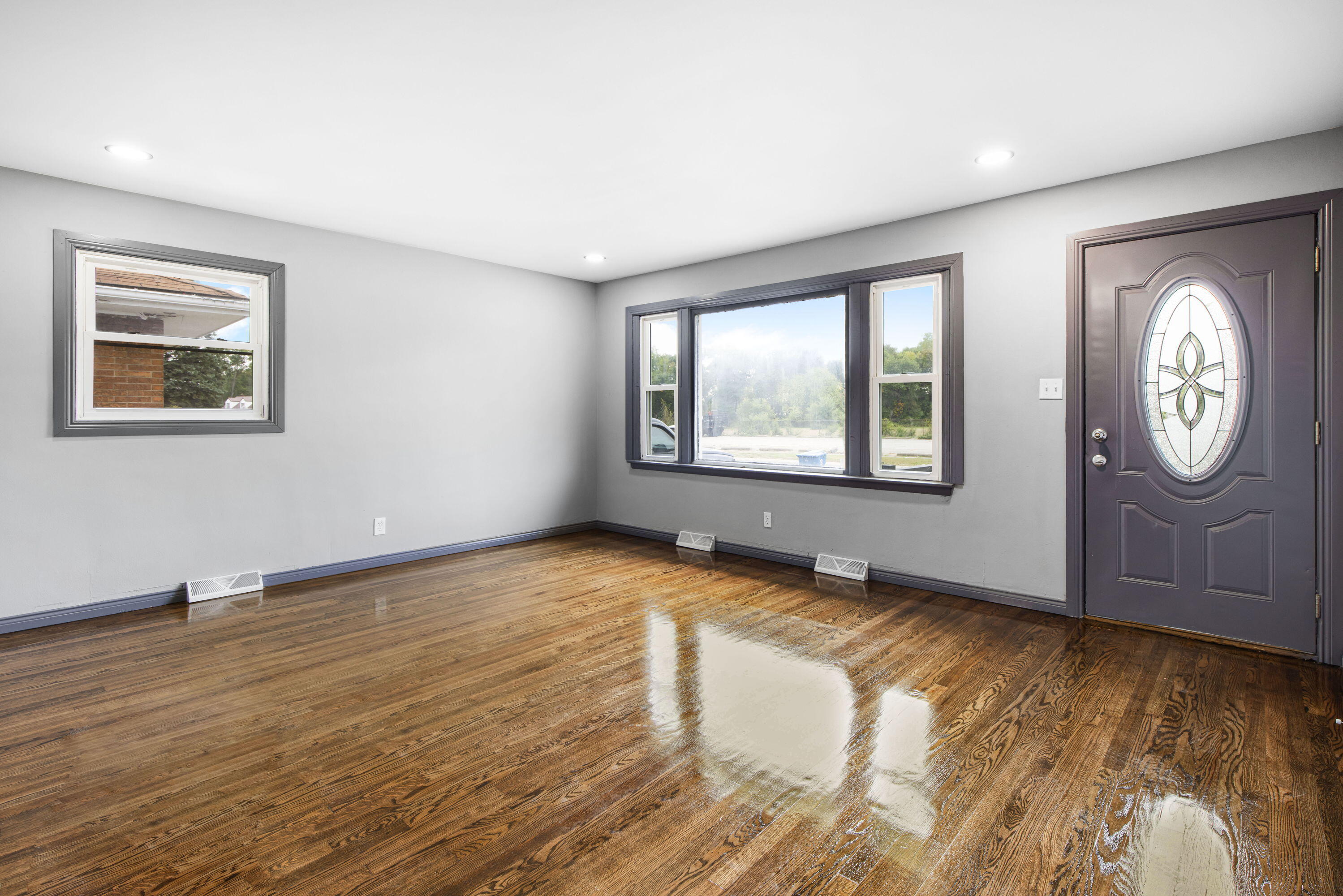 4216 East 13th Avenue Gary, IN 46403 - Photo 3 of 18 a view of an empty room with a window and wooden floor