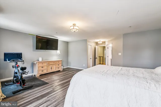 a living room with furniture a flat screen tv and a refrigerator