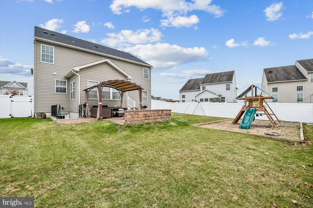 a view of a yard with plants and large trees