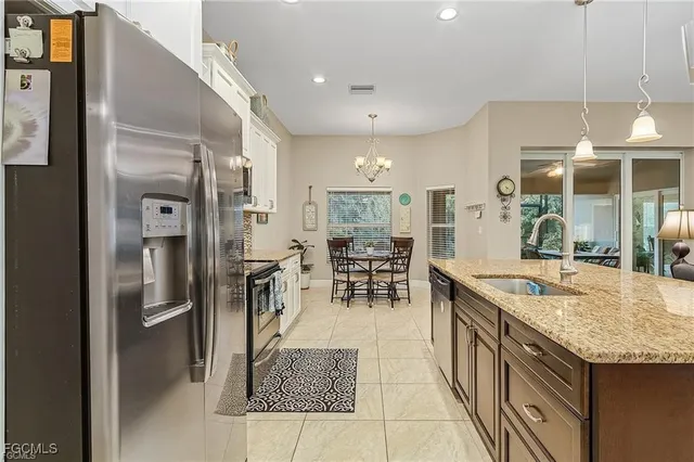 a dining hall with stainless steel appliances granite countertop a refrigerator and a counter top space