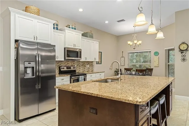 a kitchen with granite countertop a stove refrigerator and microwave