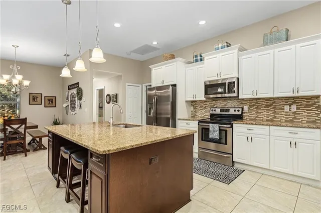 a kitchen with kitchen island granite countertop a stove a sink a oven a dining table and chairs
