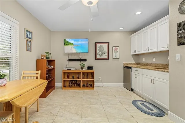 a kitchen with stainless steel appliances a stove top oven a sink a dining table and chairs