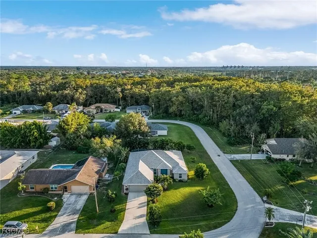 an aerial view of residential houses with outdoor space and ocean view