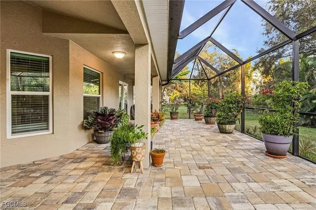 a view of a backyard with chair and potted plants