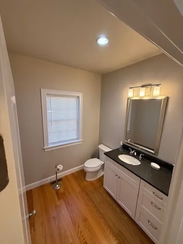 a living room with stainless steel appliances furniture a kitchen view and wooden floor
