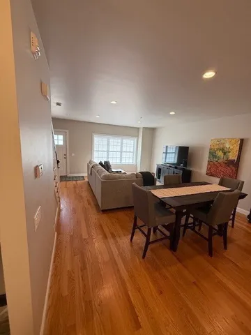a view of a hallway with wooden floor and a ceiling fan