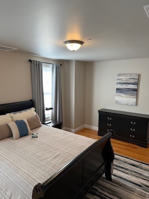 176 Main Street, Unit 3 Medway, MA 02053 - Photo 20 of 26 a bedroom with a bed and wooden floor