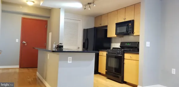 a kitchen with stainless steel appliances granite countertop a stove microwave and refrigerator