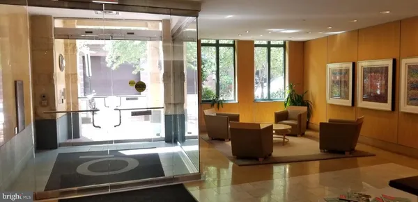 a living room with furniture a large window and wooden floor
