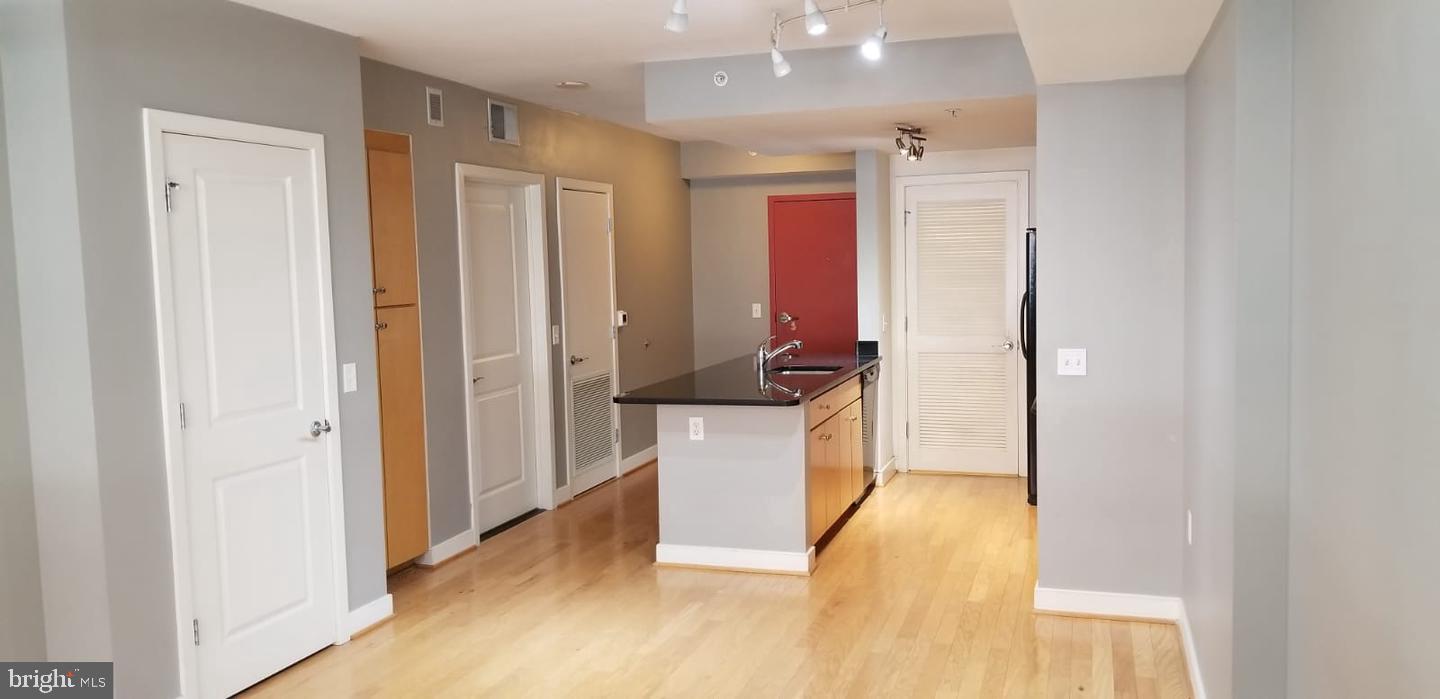 1117 10th Street Northwest, Unit 210 Washington, DC 20001 - Photo 7 of 15 a view of a hallway with wooden floor and a living room