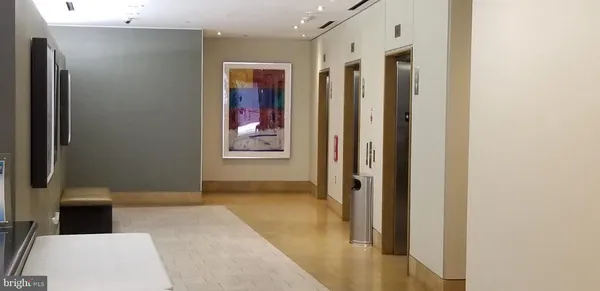 a view of a hallway with wooden floor and a bathroom