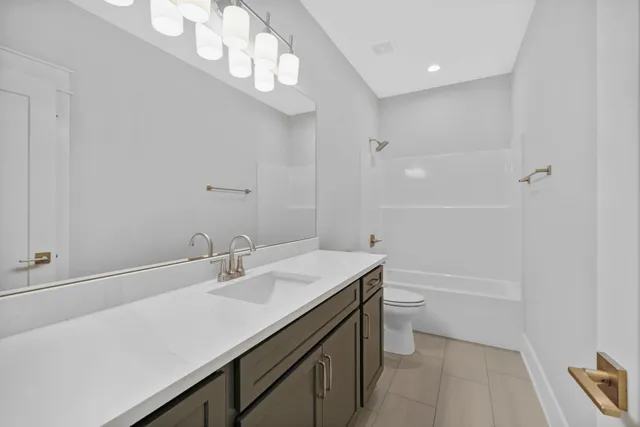 a bathroom with a sink a toilet a mirror and shower