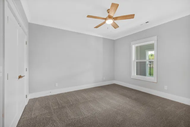 an empty room with a window and a fan