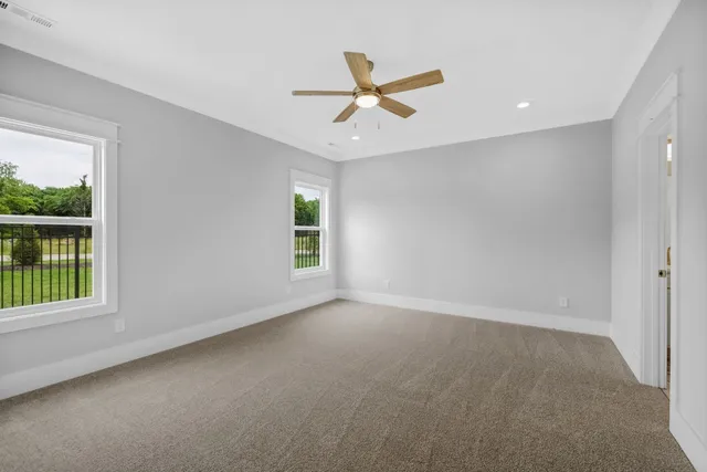 an empty room with windows and fan