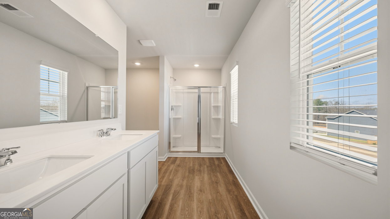 8578 Seabiscuit Road Lithonia, GA 30058 - Photo 24 of 30 a spacious bathroom with a shower sink and a mirror
