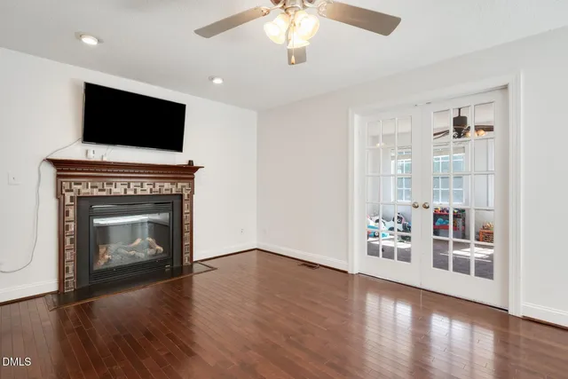 a view of an empty room with window and wooden floor