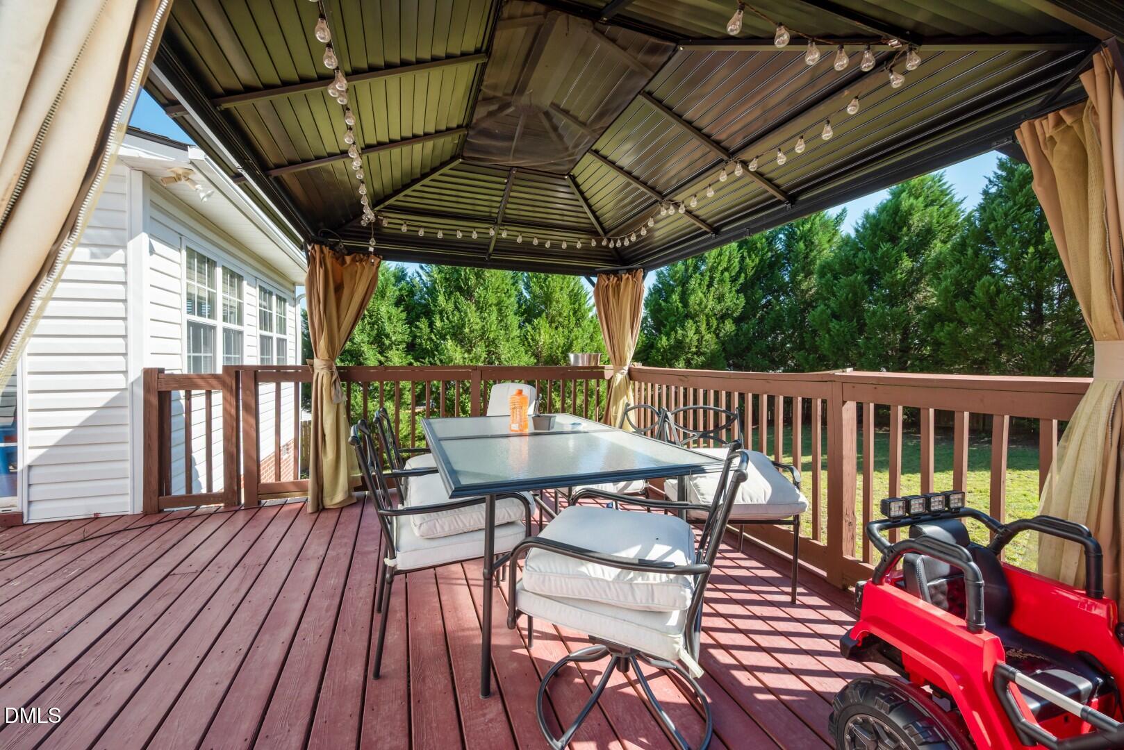 66 Snowden Lane Cameron, NC 28326 - Photo 2 of 55 a view of a patio with table and chairs under an umbrella with wooden floor