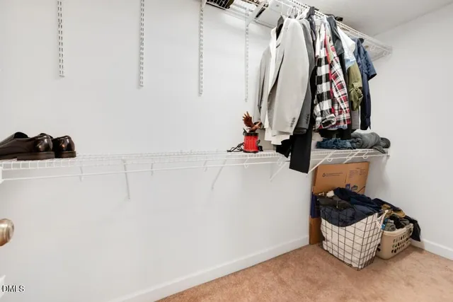 a view of walk in closet with clothes and shoes