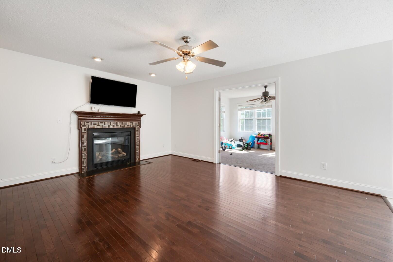 66 Snowden Lane Cameron, NC 28326 - Photo 5 of 55 a view of a livingroom with a flat screen tv wooden floor and a ceiling fan
