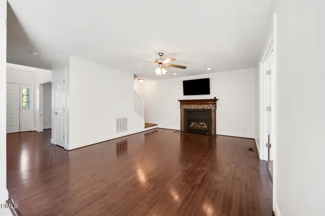 a view of a livingroom with a flat screen tv wooden floor and a ceiling fan