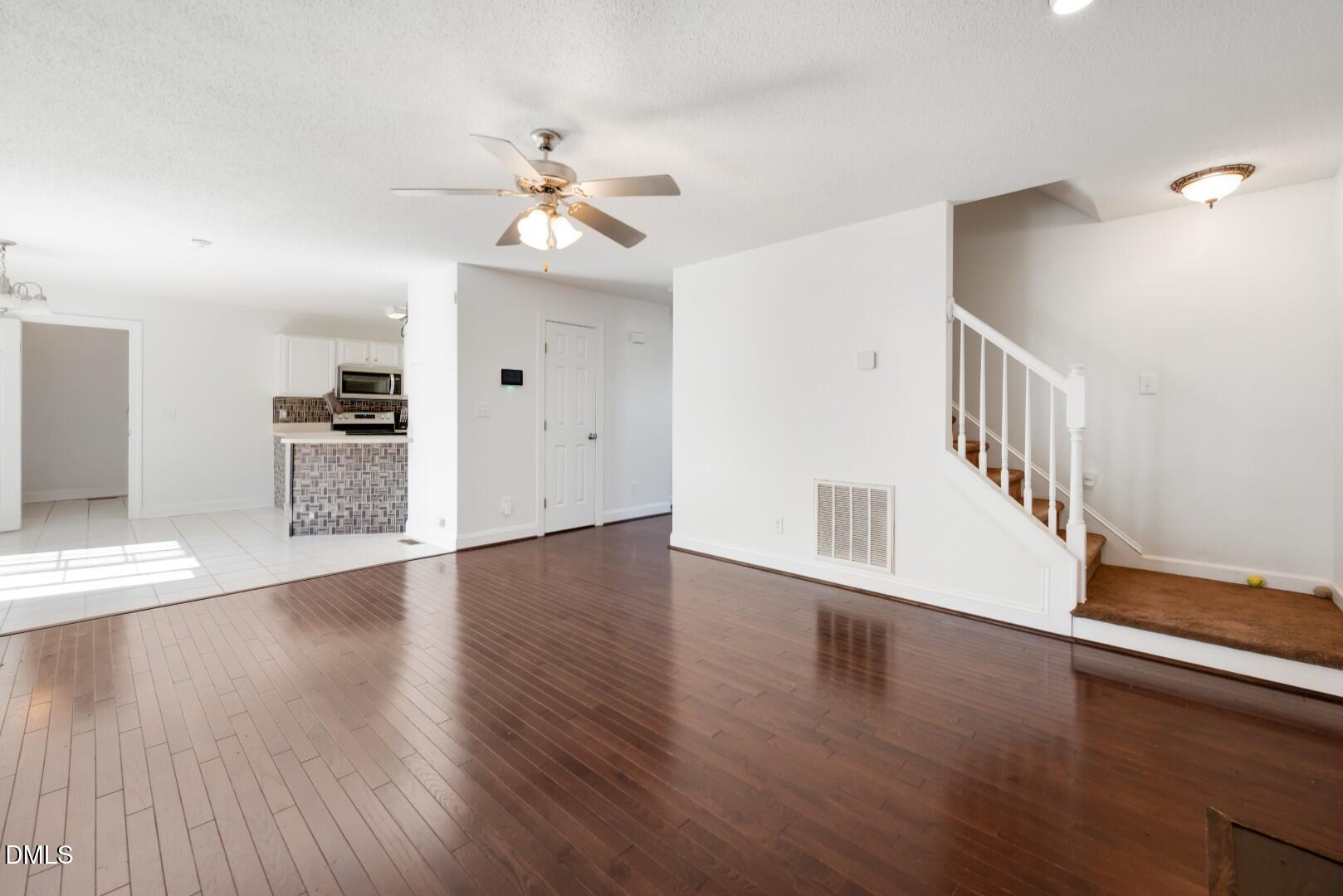 66 Snowden Lane Cameron, NC 28326 - Photo 7 of 55 a view of an empty room with wooden floor and a ceiling fan