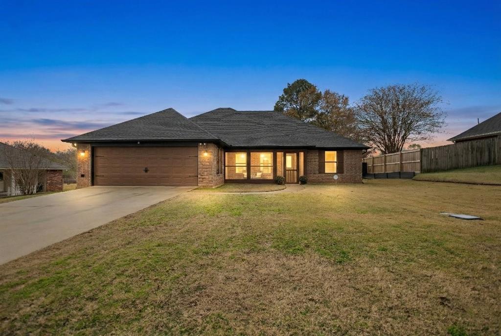 View of front facade featuring concrete driveway, brick siding, and a garage