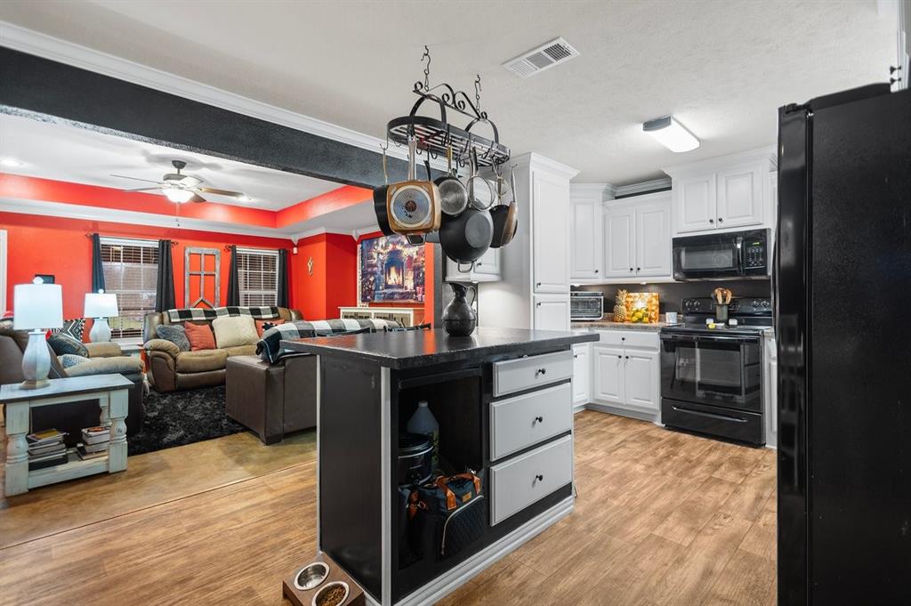 202 Spring Valley Queen City, TX 75572 - Photo 34 of 35 Kitchen featuring black appliances, white cabinetry, open floor plan, dark countertops, and light wood-type flooring