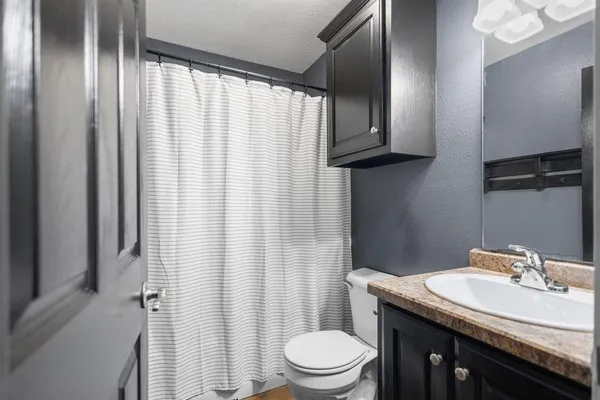 a bathroom with a granite countertop sink toilet and shower