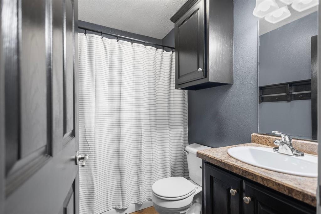 202 Spring Valley Queen City, TX 75572 - Photo 21 of 35 Full bathroom with vanity, a shower with shower curtain, a textured wall, and a textured ceiling