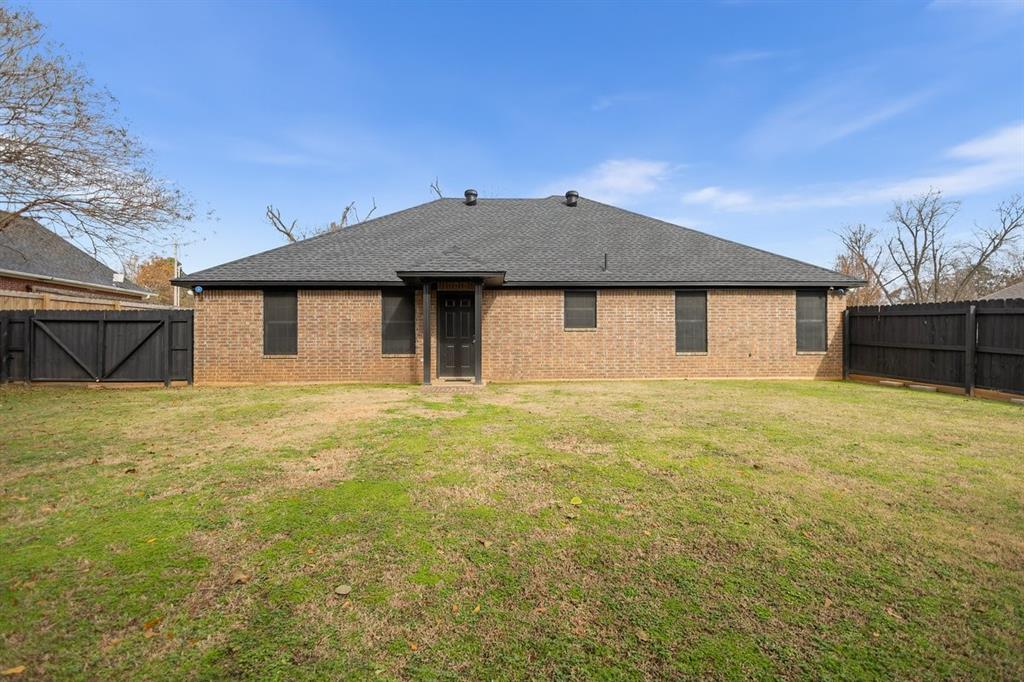 202 Spring Valley Queen City, TX 75572 - Photo 25 of 35 Rear view of property with a fenced backyard, a shingled roof, brick siding, and a gate