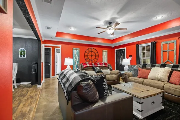 a living room with furniture a ceiling fan and a rug