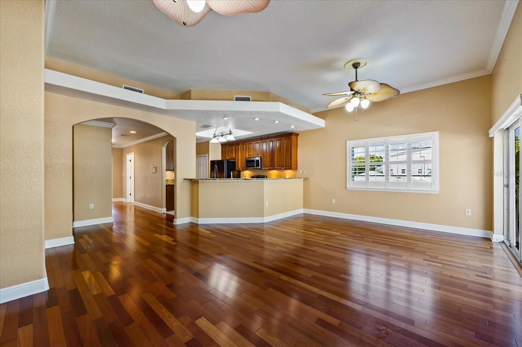 136 175th Avenue East Redington Shores, FL 33708 - Photo 11 of 40 a view of a big room with wooden floor and a kitchen