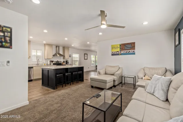 a living room with furniture kitchen view and a chandelier