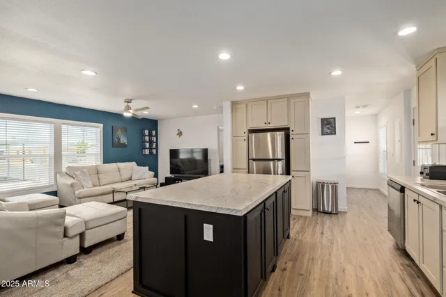 a open kitchen with stainless steel appliances granite countertop a refrigerator and a stove top oven