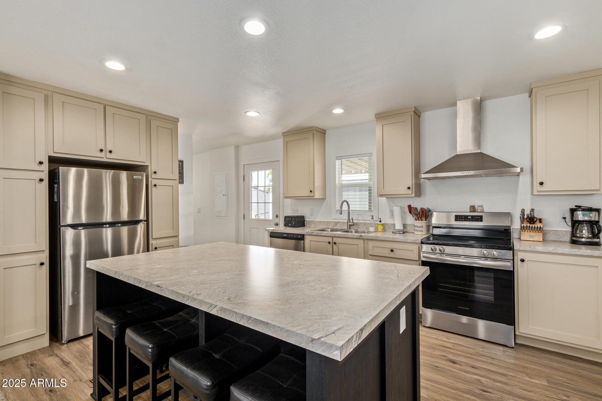 501 East Ray Road, Unit 201 Chandler, AZ 85225 - Photo 5 of 28 a large kitchen with kitchen island a stove a sink a refrigerator and white cabinets with wooden floor