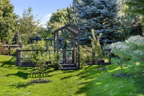 a backyard of a house with a garden and outdoor seating