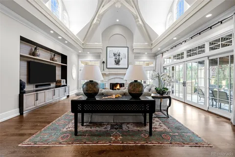 a living room with furniture a flat screen tv and a floor to ceiling window