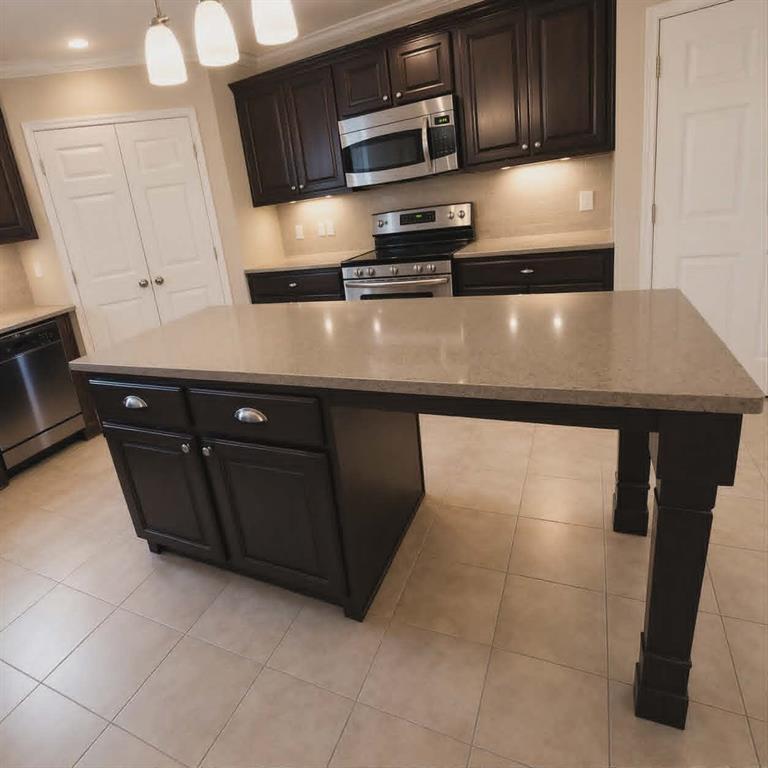 14752 Ranch Road Forney, TX 75126 - Photo 11 of 40 Kitchen island with an extended countertop, dark wood-finish cabinetry, stainless steel appliances, and tiled flooring-This photo was taken before family moved in