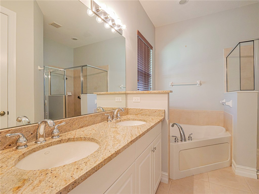1965 Bridgepointe Circle, Unit 84 Vero Beach, FL 32967 - Photo 19 of 33 a bathroom with a granite countertop sink and a mirror