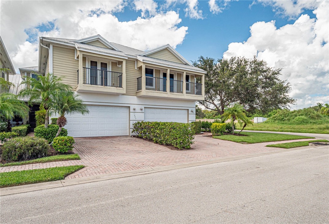 1965 Bridgepointe Circle, Unit 84 Vero Beach, FL 32967 - Photo 2 of 33 a front view of a house with a yard and garage