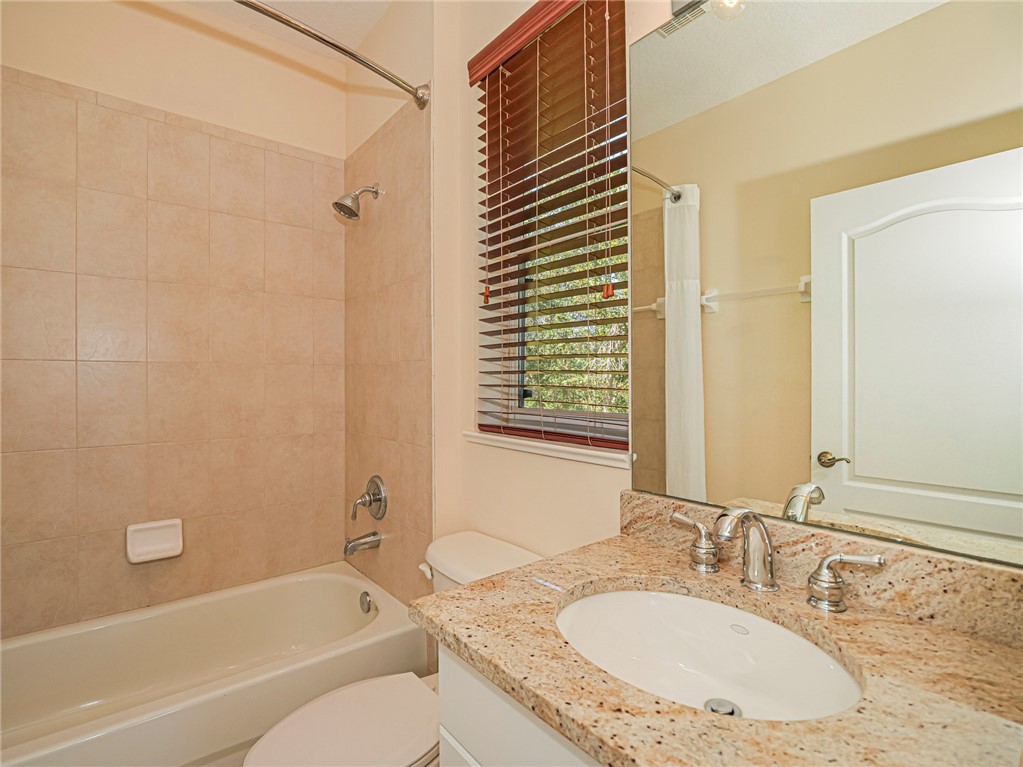 1965 Bridgepointe Circle, Unit 84 Vero Beach, FL 32967 - Photo 27 of 33 a bathroom with a granite countertop tub sink and mirror