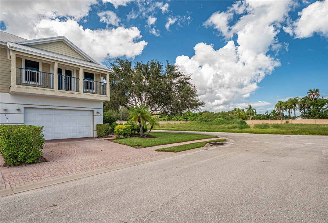 1965 Bridgepointe Circle, Unit 84 Vero Beach, FL 32967 - Photo 3 of 33 a view of a house with a yard and a large tree
