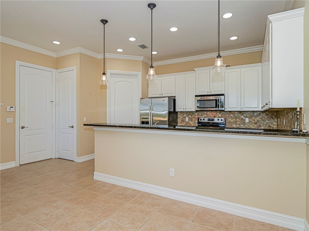 1965 Bridgepointe Circle, Unit 84 Vero Beach, FL 32967 - Photo 9 of 33 a view of a kitchen with stainless steel appliances granite countertop a refrigerator a sink and a stove