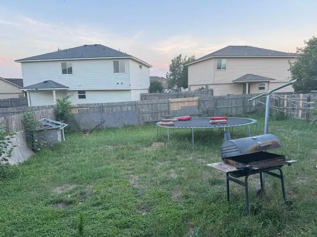 a backyard of a house with table and chairs
