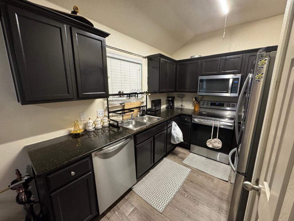 13409 Pine Needle Street Manor, TX 78653 - Photo 5 of 12 a kitchen with a sink stove and microwave