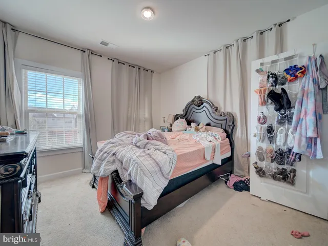 a bed sitting in a bedroom next to a window