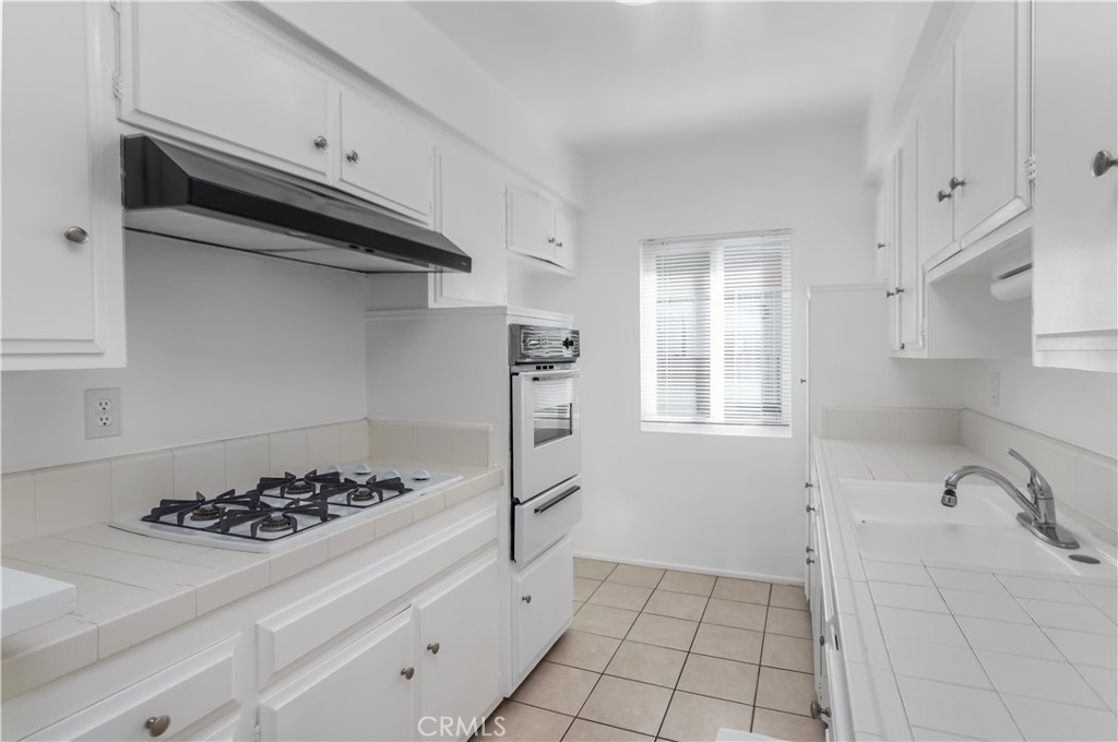 3662 Keystone Avenue, Unit 7 Los Angeles, CA 90034 - Photo 6 of 14 a kitchen with a stove a sink and cabinets