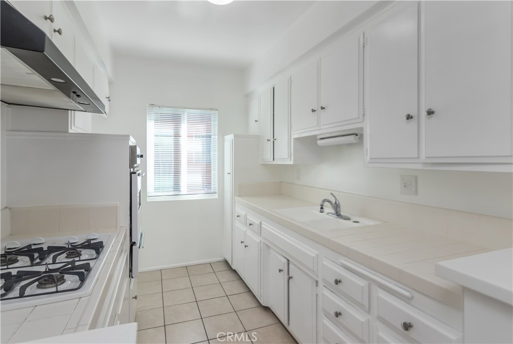 3662 Keystone Avenue, Unit 7 Los Angeles, CA 90034 - Photo 7 of 14 a kitchen with a sink stove and cabinets