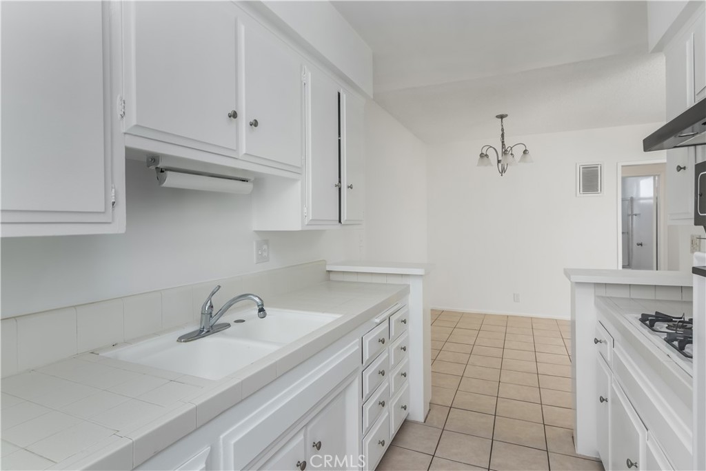 3662 Keystone Avenue, Unit 7 Los Angeles, CA 90034 - Photo 8 of 14 a kitchen with white cabinets sink and stove